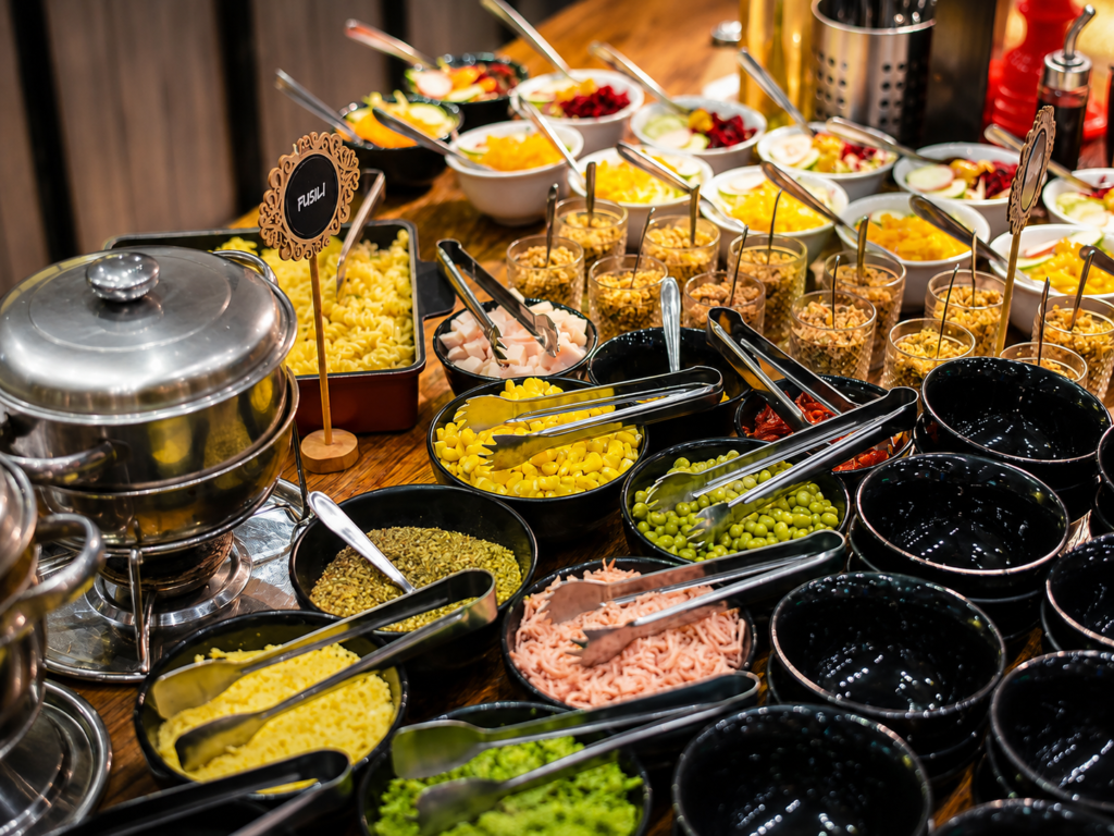 Variedade de pratos e acompanhamentos servidos em buffet para festa infantil