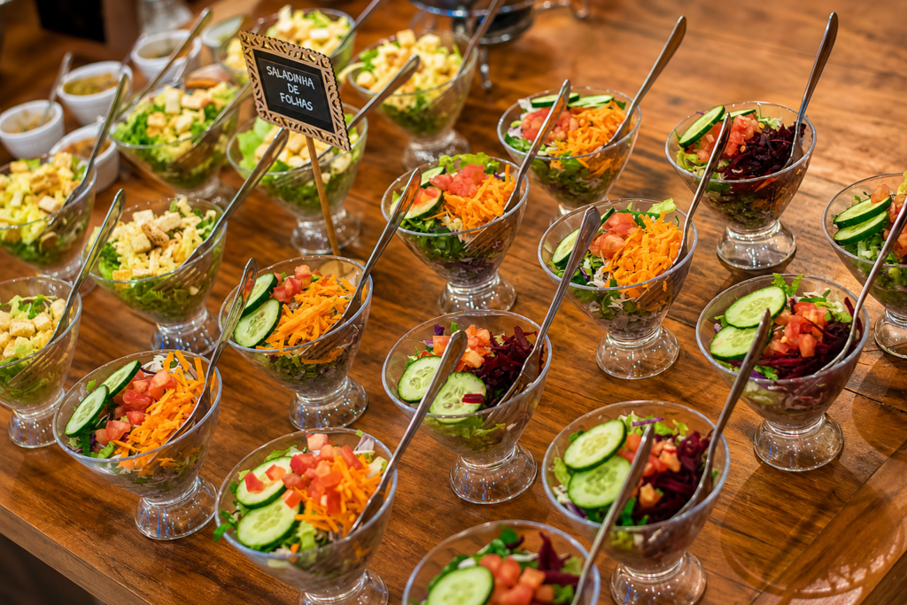Mesa com variedade de entradas, saladas e acompanhamentos para festa infantil